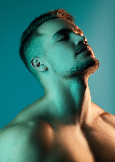 Theres something enticing about his personality Studio shot of a handsome young man posing against a blue background