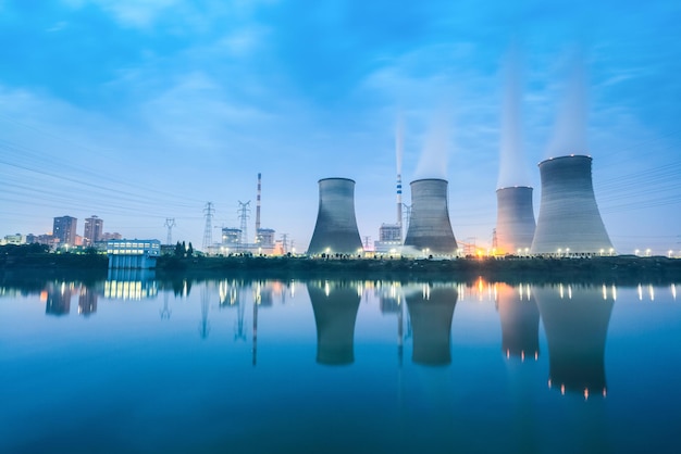 Photo thermal power plant in nightfall cooling towers and reflection in the riverxaxa