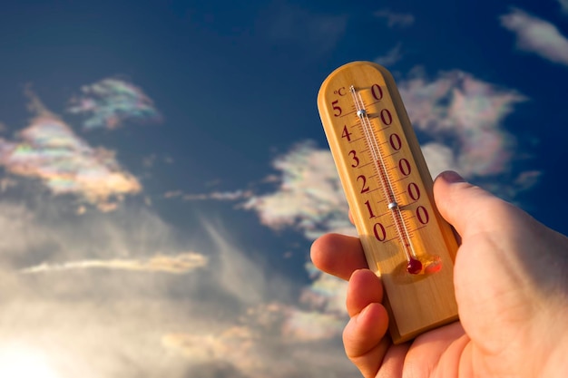 Foto termometro per misurare la temperatura in natura sullo sfondo del cielo durante il caldo estivo