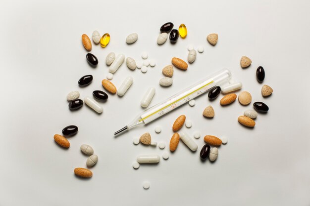 Thermometer, pills and vitamines isolated over a white background