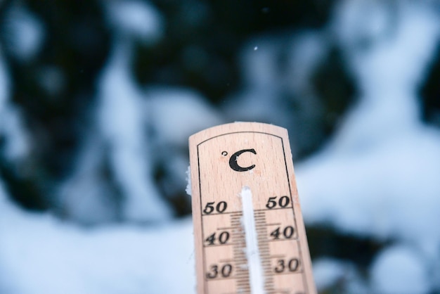 겨울에 섭씨 또는 화씨의 낮은 온도로 눈 위의 온도계.