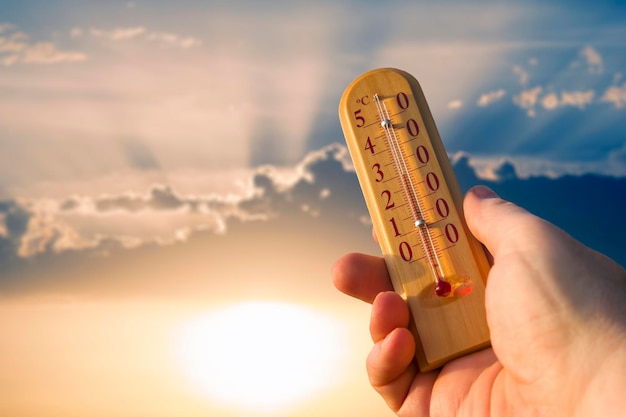 Foto thermometer voor het meten van temperatuur in de natuur tegen de achtergrond van de lucht in het warme zomerweer