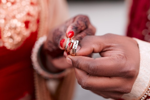 These pieces of jewelry symbolize our forever Cropped shot of an unrecognizable couple holding their wedding rings together on their wedding day