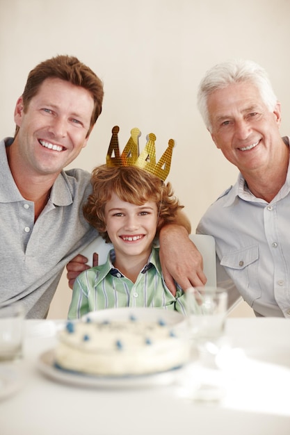 They grow up so fast shot of a happy birthday boy sitting with his father and grandfather