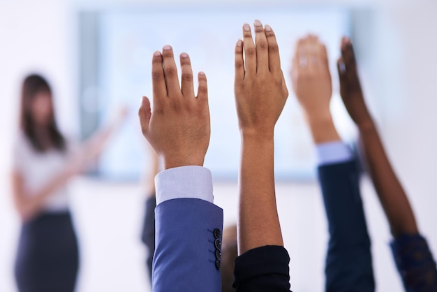 They have all the answers Shot of a group of people raising their hands in a class