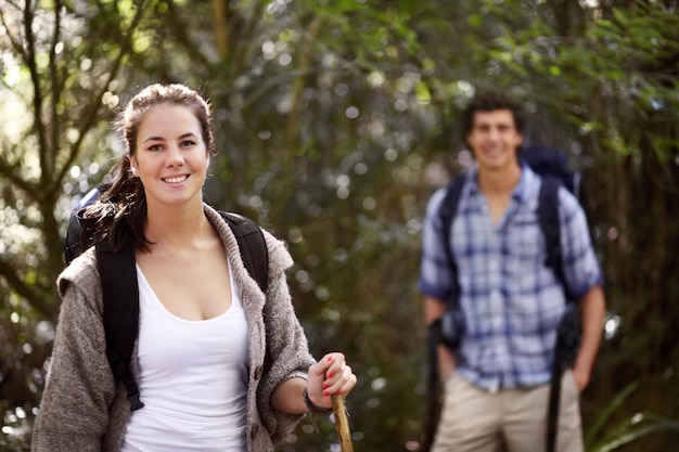 They love being outdoors together Portrait of a young woman with her boyfriend in the background