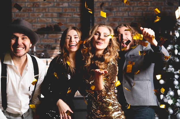 They love dancing. Group of beautiful young people dancing with champagne flutes and looking happy.