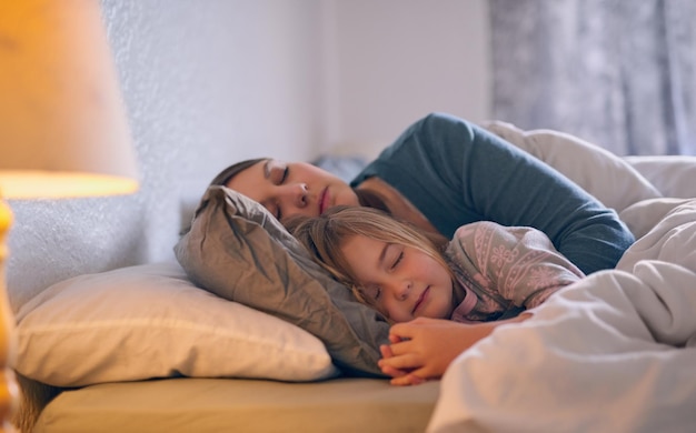 They spend every possible moment together Shot of a mother and her little girl sleeping in bed together