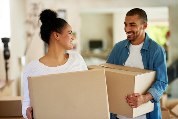 Theyre finally moving in together Shot of a happy young couple carrying cardboard boxes into their new home