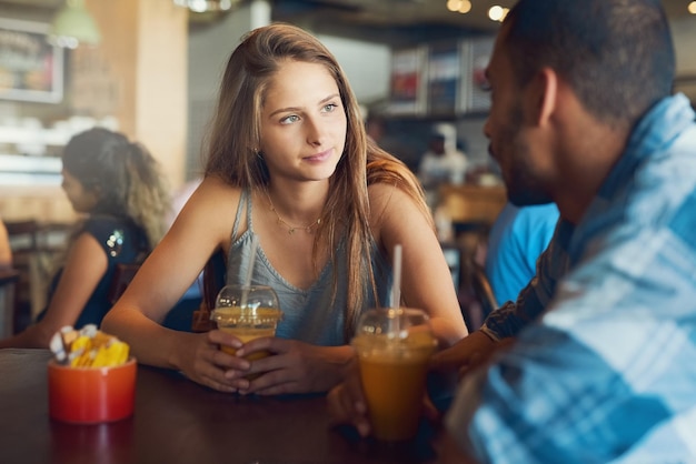 Theyve got loads to catch up on Cropped shot of a young couple on a date in a cafe