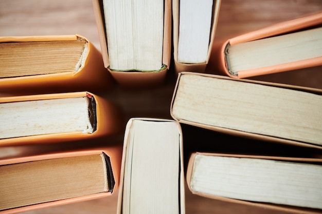 Thick books on table, view from above, selective focus