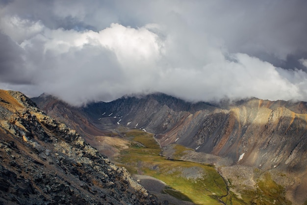 写真 濃い霧がロッキー山脈の頂上を覆っている曇りの日の山の谷の壮大で雄大な景色