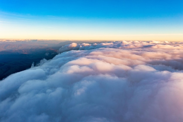 日の出の山の上の白い雲の厚い層