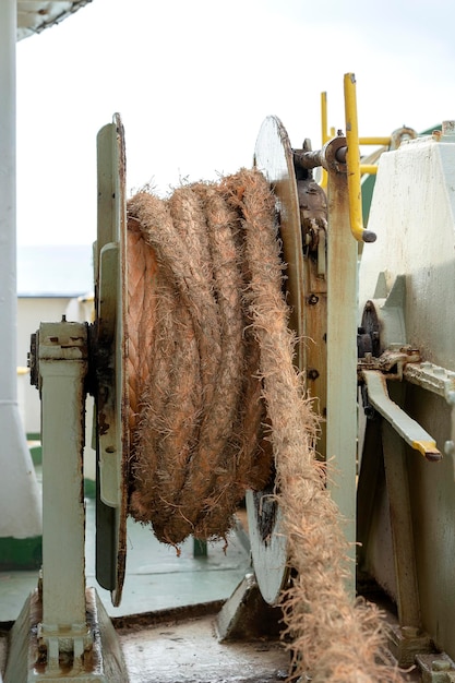 A thick rope is wrapped around a drum on deck of a ferry boat Thailand Closeup