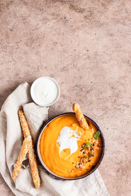 Spessa purea di zuppa setosa fatta di carota di zucca e patata dolce con semi di crema e menta