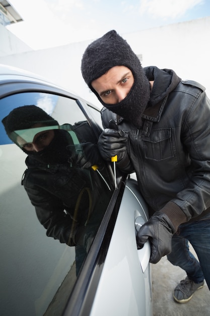 Thief breaking into a car