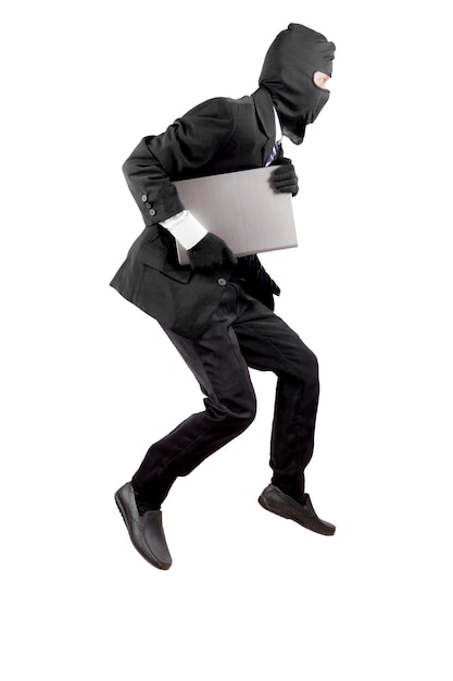 Photo thief dressed in black and wearing a balaclava stealing a laptop computer isolated over white background