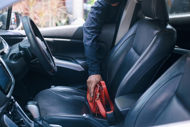 Photo a thief in a robbery mask stealing a purse bag in a car