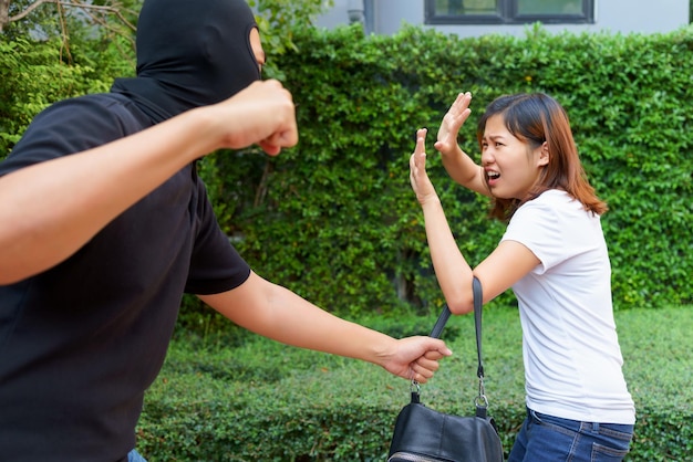 Foto un ladro ruba la borsa di una donna nel parco.