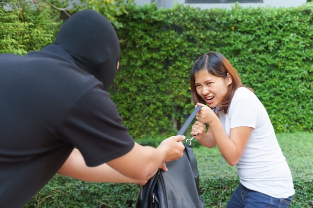 Foto un ladro ruba la borsa di una donna nel parco.