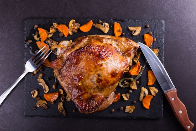 Thigh turkey baked in the oven with spices on black stone background. Healthy food. Thanksgiving dinner.