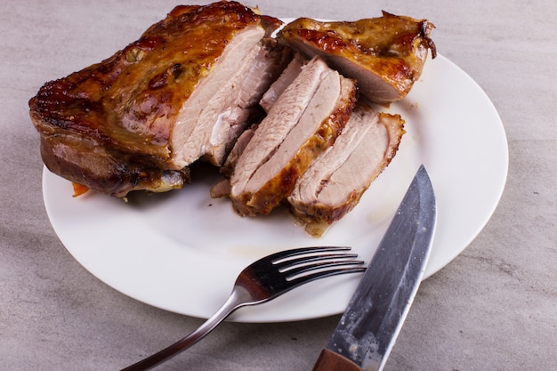 Thigh turkey baked in the oven with spices on a white plate on the tabletop. Healthy food. Thanksgiving dinner.