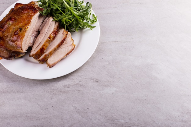 Thigh turkey baked in the oven with spices on a white plate on the tabletop. Healthy food. Thanksgiving dinner.