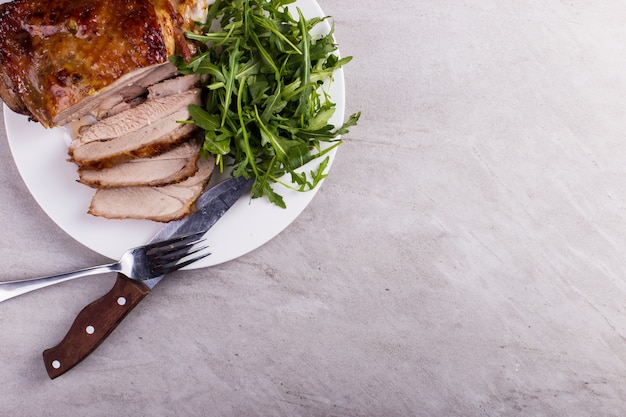 Photo thigh turkey baked in the oven with spices on a white plate on the tabletop. healthy food. thanksgiving dinner.