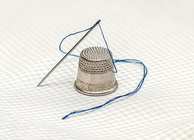 Thimble and needle with thread on a napkin