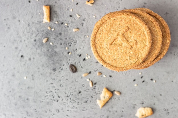 Thin crispy wholegrain crackers with seeds on grey concrete . 