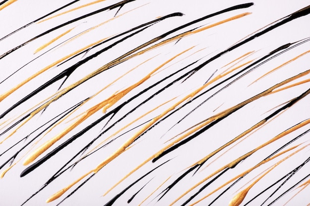 Thin golden and black lines and splashes drawn on white background