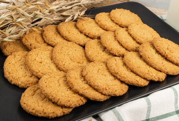 Thin oatmeal cookies or healthy cereal oat crackers closeup. Crispy anzac biscuit cookie with oat flakes on rustic table background