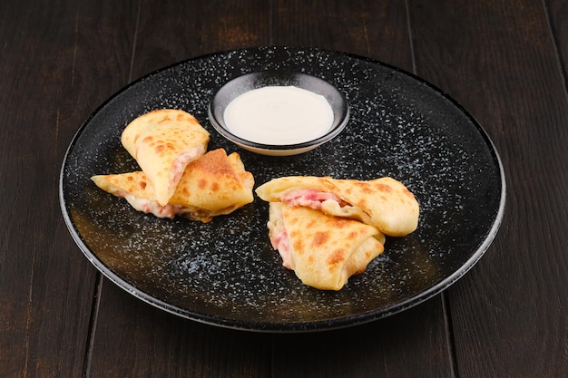 Thin pancakes stuffed with ham and cheese