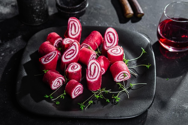 Thin red pancakes. Rolls of beetroot pancakes with cream cheese