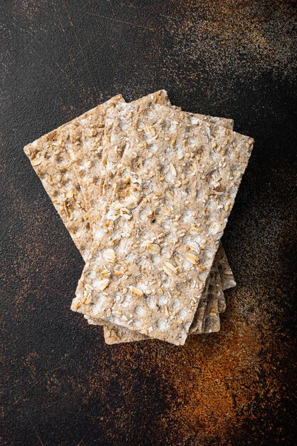 Thin rye crispy cracker on old dark rustic table background top view flat lay