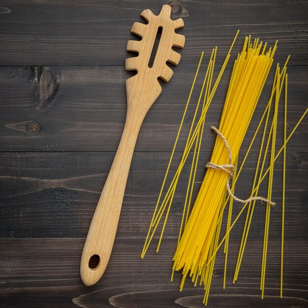 The thin spaghetti on black wooden background. 