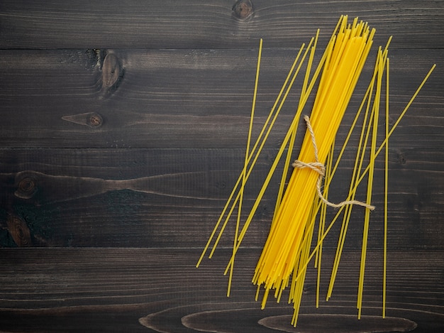 The thin spaghetti on black wooden background. 