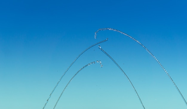 Thin streams and drops of water on a blue background