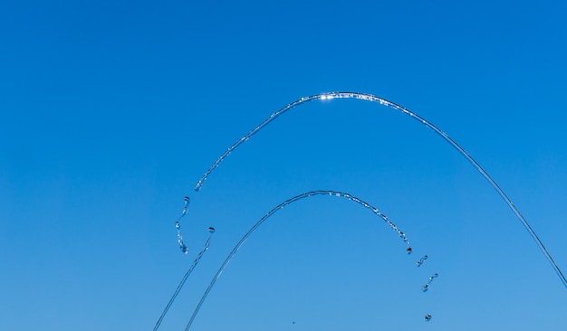 Thin streams and drops of water on a blue background