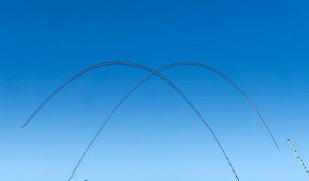 Thin streams and drops of water on a blue background