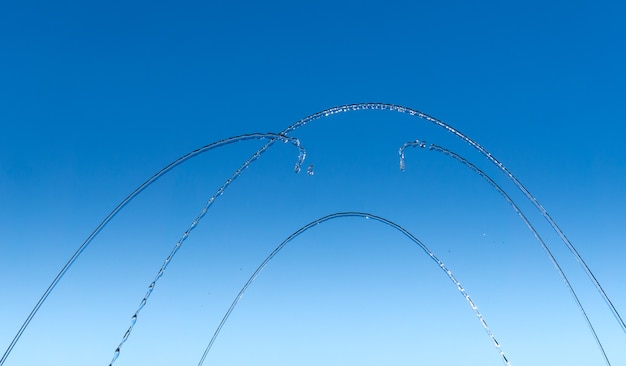 Thin streams and drops of water on a blue background