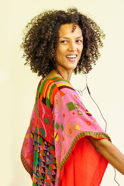 Thin woman smiling with afro hair, white background freestyle