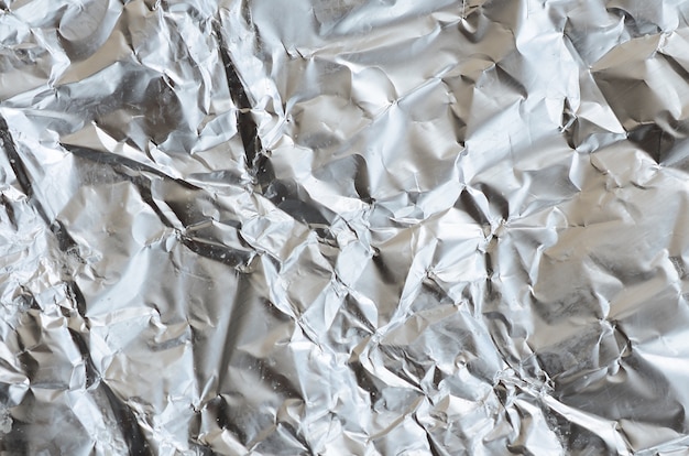 Thin wrinkled sheet of crushed tin aluminum silver foil