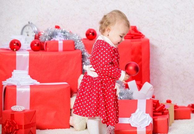 Cose da fare con i bambini a natale regali di natale per i più piccoli regali per il primo natale dei bambini la bambina gioca vicino a un mucchio di scatole regalo vacanze in famiglia festeggia il primo natale