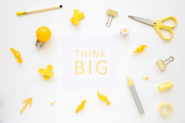 Photo think big words surrounded by various electric bulb, candies and stationeries