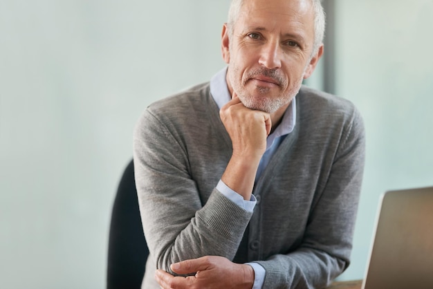 Think business Portrait of a mature businessman looking thoughtful while sitting in his office