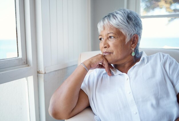 Thinking back Cropped shot of an attractive senior woman looking nostalgic while sitting in the old age home