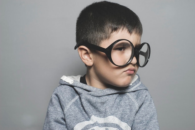 考えて、大きな眼鏡をかけた少年は非常に真剣に考えています