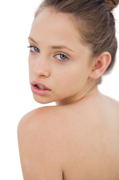 Thinking brunette model posing looking over her shoulder