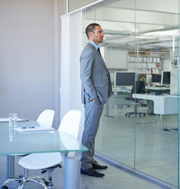 thinking business and man at window in office planning for future decision or choice in london professional entrepreneur or problem solving in conference room with expert idea or brainstorming